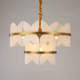 Niori Petraia two-tier floral chandelier with sculpted alabaster petals on brushed brass rings, suspended from a gold fabric cable against a grey background.