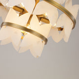 Close-up of Niori Petraia 2 Tier Floral Alabaster Chandelier showing brushed brass rings, lit E14 lamps and layered white alabaster petals.