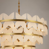 Close-up of the Niori Petraia floral chandelier showing tiered brushed brass rings edged with white alabaster petals and a sculpted brass stem.