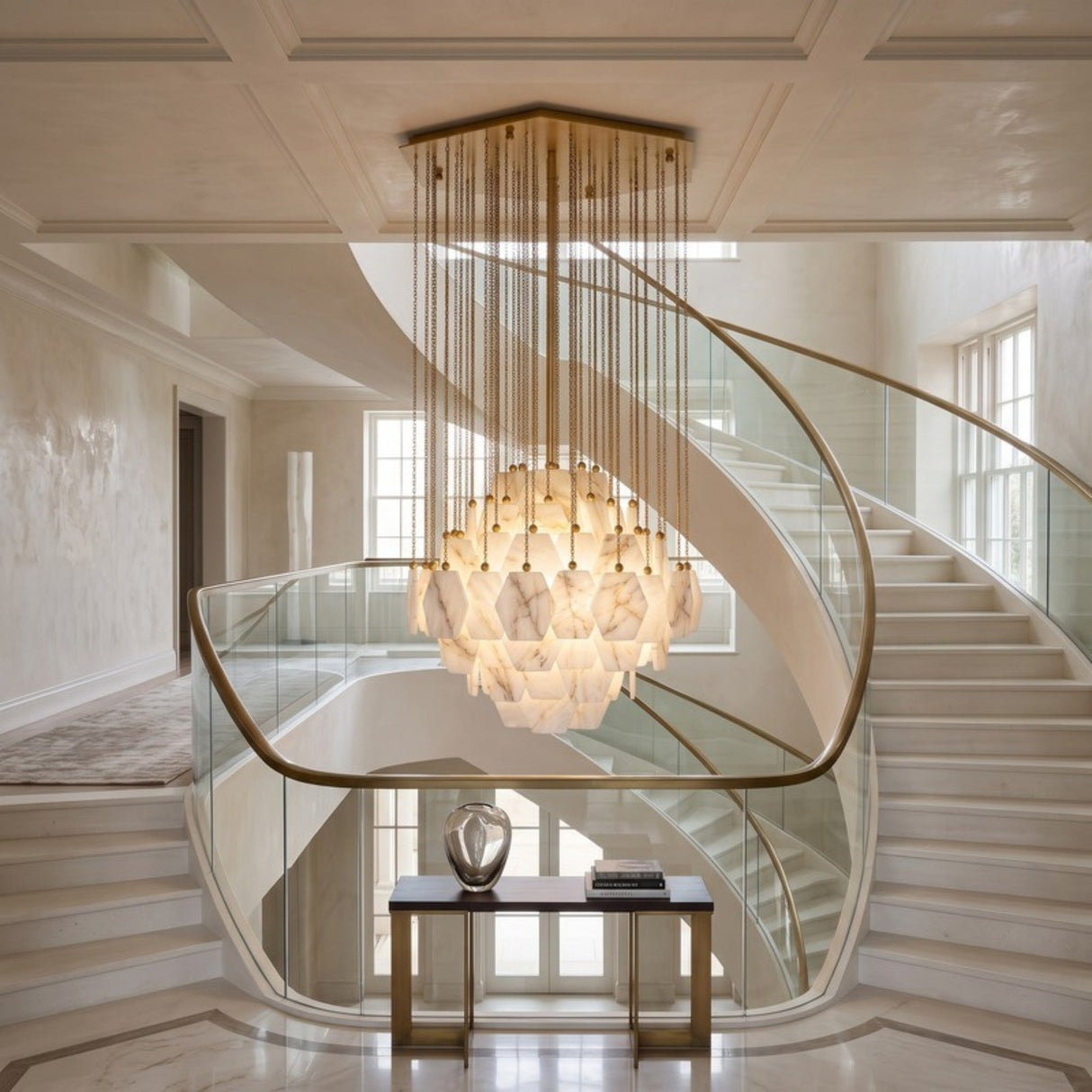 Cascatella LED Tiered Alabaster Chandelier 70cm in brass, hexagonal alabaster tiles in a domed tiered body with cascading brass chains, shown above a curved staircase.