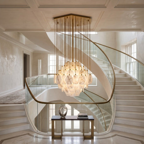 Cascatella LED Tiered Alabaster Chandelier 70cm in brass, hexagonal alabaster tiles in a domed tiered body with cascading brass chains, shown above a curved staircase.