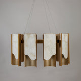 Niori Caelith LED large circular chandelier with stepped Spanish alabaster panels and brushed brass blades, suspended on steel cables against a grey background.