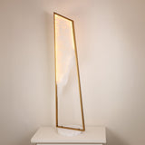 Atria LED Large alabaster floor lamp by Niori with a tall brushed brass frame and circular white marble base, illuminated on a light console.