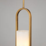 Niori Eliona Capsule Alabaster Pendant Light in brushed brass, with an arched capsule frame surrounding a cylindrical alabaster shade, lit warm.