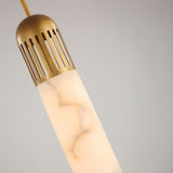 Zerith LED Alabaster Tube Pendant Light in Brushed Brass, close-up of the fluted brass collar and marbled alabaster cylinder against a plain grey background.