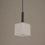 Draxen alabaster drum pendant light with cube-shaped white shade and matte black stem, shown against a plain grey background.
