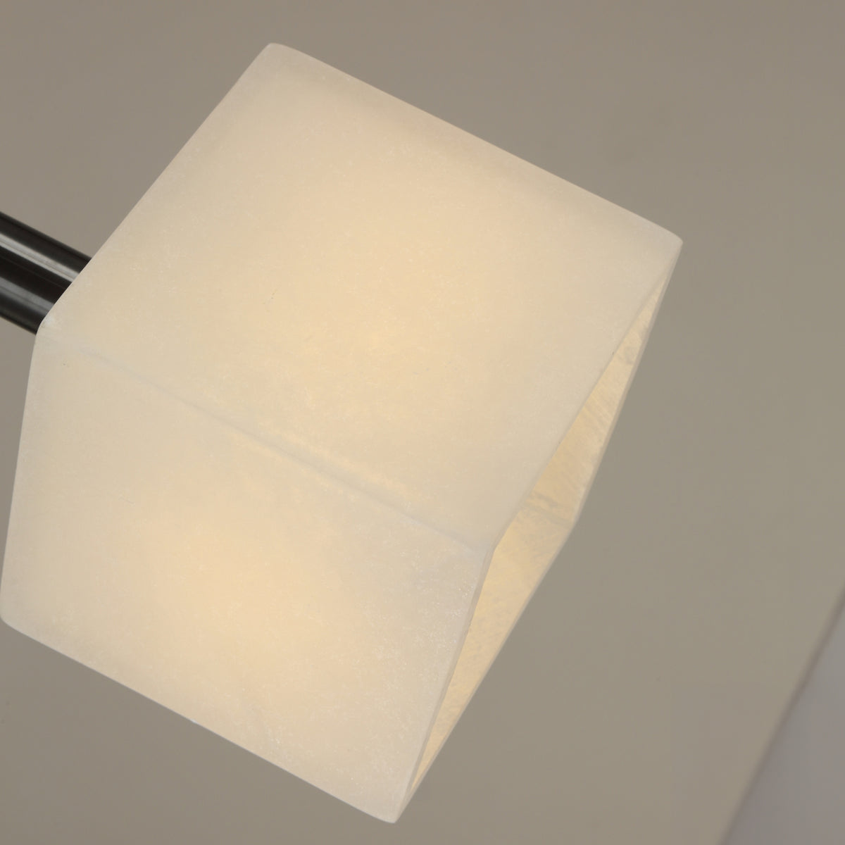 Close-up of the Draxen alabaster drum pendant light, showing the cube-like natural stone shade and matte black stem against a plain grey background.