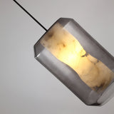 Niori Vale Faceted Alabaster Pendant Light in Soft White, angled view showing the natural stone core glowing within a clear faceted glass shell.