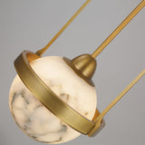 Calis Alabaster Single Pendant Light in Brushed Brass, close-up of the spherical alabaster globe held by an arched brass band and stem.