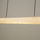 Zareon LED Large Linear Alabaster Chandelier in soft white, close-up of the cylindrical stone diffuser glowing warm white, suspended on twin black cables against a plain grey background.