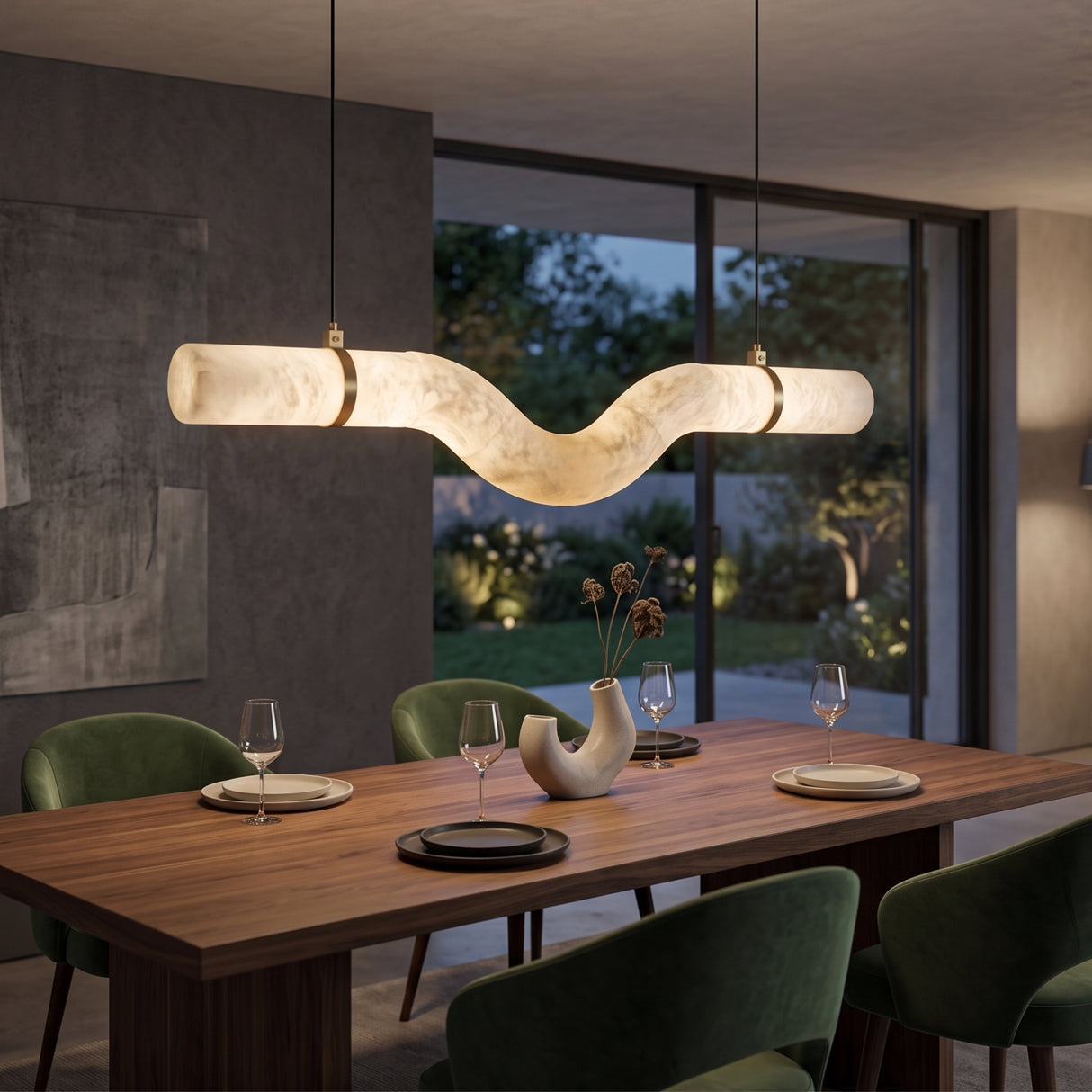 Zareon LED Medium Curved Alabaster Chandelier with brushed brass collars, illuminated above a wooden dining table with green chairs in a modern dining room.