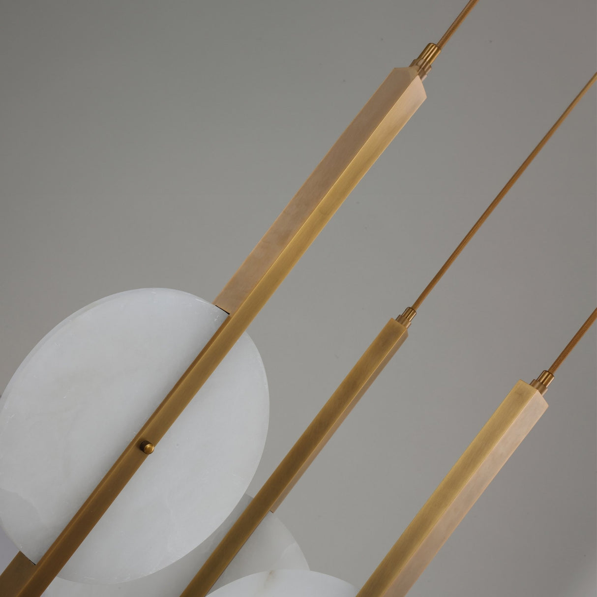 Close-up of the Niori Elyra 3 Light LED Cluster Chandelier showing brushed brass blade stems and staggered flat alabaster oval discs against a light background.