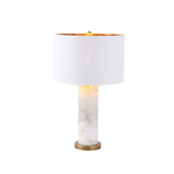 Calix Alabaster Pillar Table Lamp with white fabric drum shade, gold-toned interior, and brushed brass base, shown lit against a plain white background.