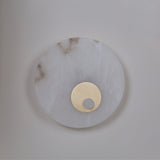Selvana LED Small Alabaster Wall Light in soft white, a round natural alabaster disc with a brushed brass centre boss, shown against a plain light background.