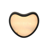 Niori Marea LED wall light with teardrop-shaped natural Spanish alabaster panel set in a matte black copper frame, shown illuminated on a white background.