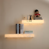 Niori Kate LED alabaster wall shelf lights in soft white, arranged in a staggered layout with books, rabbit figurines and a guard teddy bear on display.