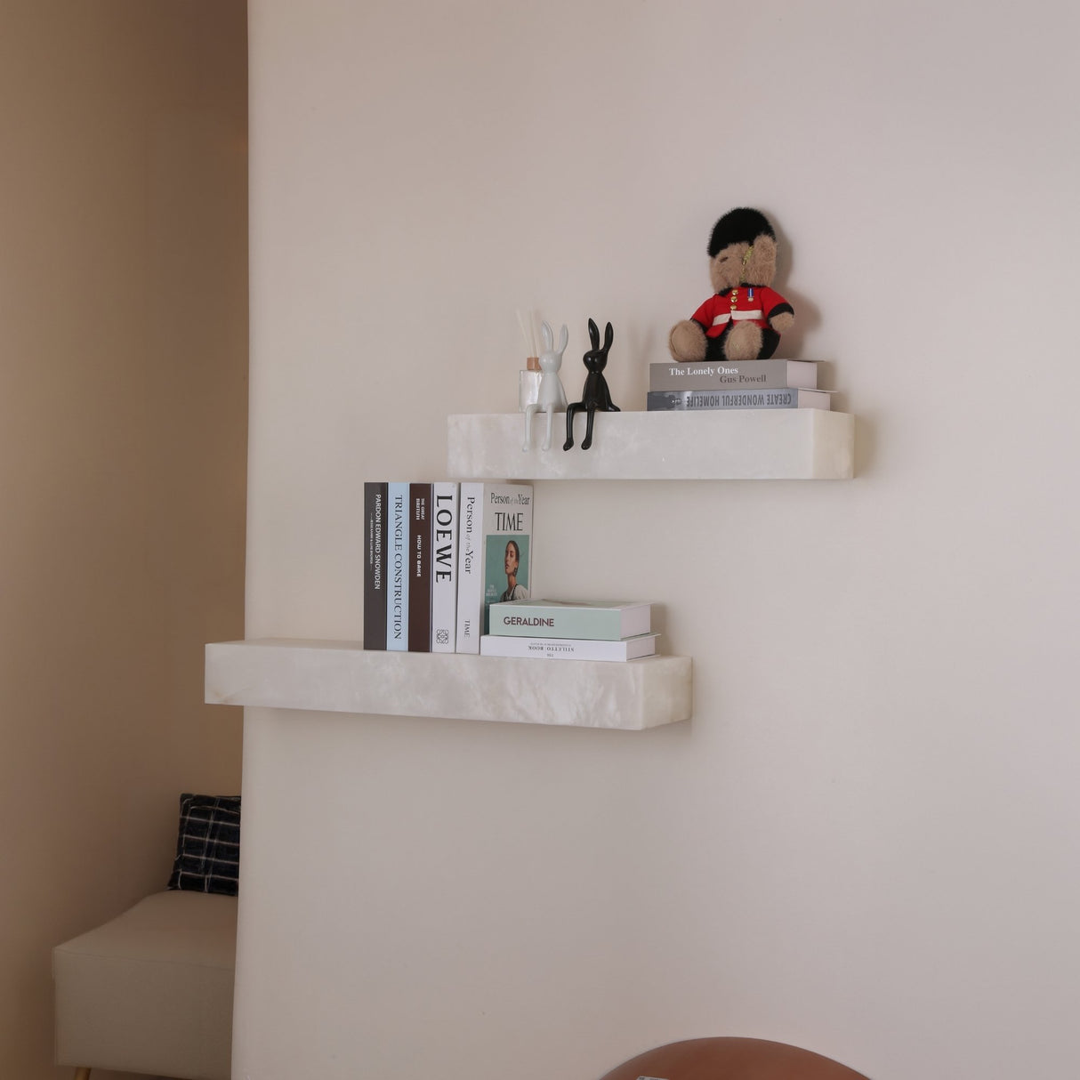 Niori Kate LED alabaster wall shelves in soft white, styled with books, rabbit figurines and a guardsman teddy in a neutral living space.