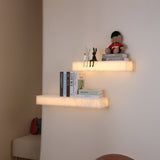 Niori Kate LED alabaster wall shelf lights in soft white, mounted in pairs displaying books, figurines and a guardsman teddy in a softly lit corner.
