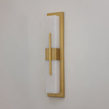 Niori Caldera Large LED wall light with a tall Spanish alabaster column, brushed brass backplate and vertical brass band, shown against a pale wall.
