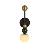 Niori Zeal Vertical Orb wall light with stacked brushed brass and matt black spheres above a glowing alabaster globe, on a plain white background.