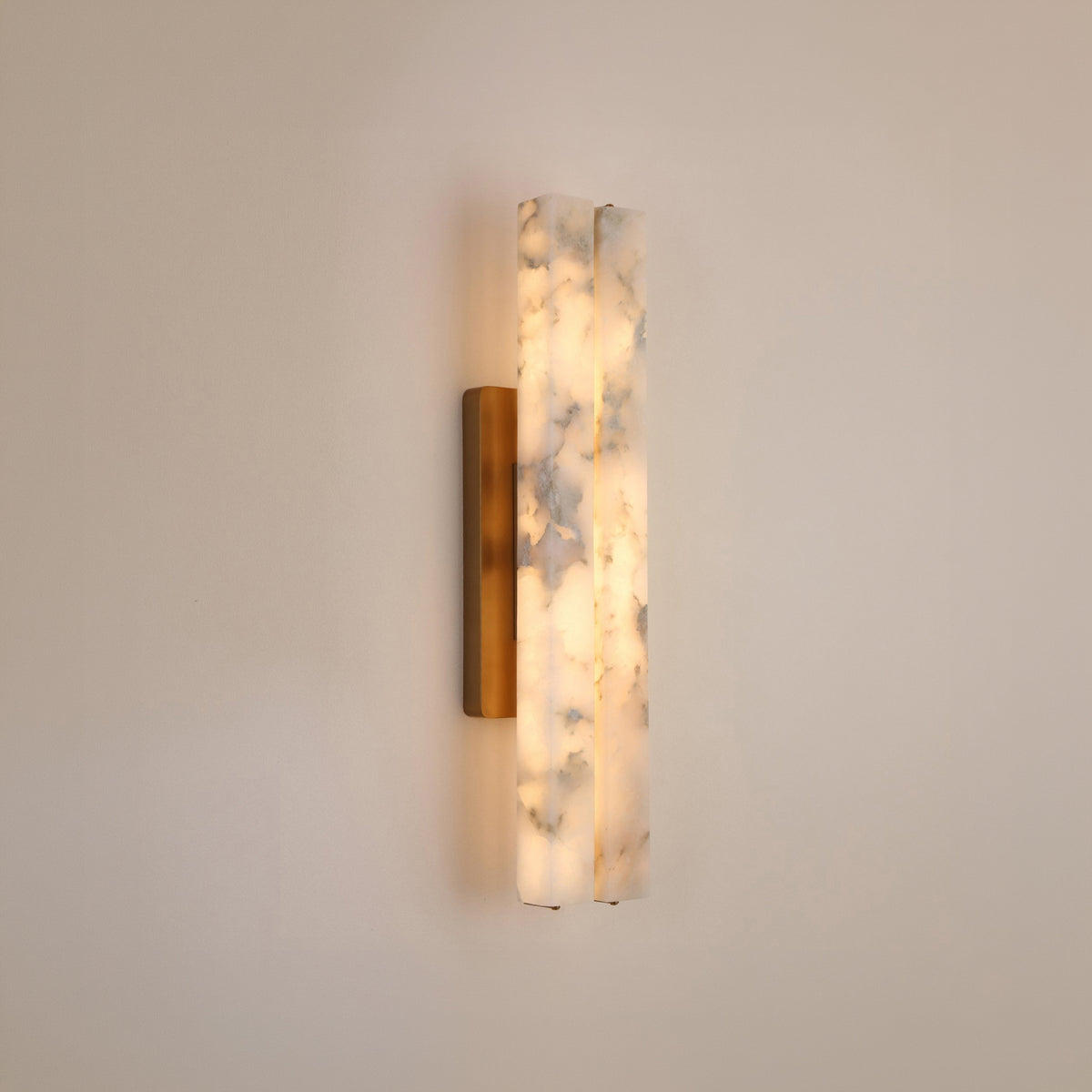 Selvara LED Small Alabaster Double Wall Light in brushed brass, featuring two offset vertical alabaster panels glowing warm white on a plain light background.