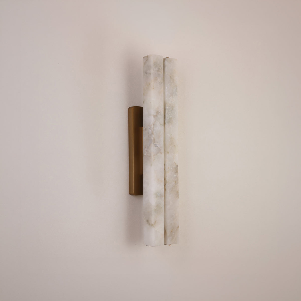 Selvara Small LED double wall light with two offset alabaster panels on a brushed brass rectangular backplate, mounted on a plain neutral wall.