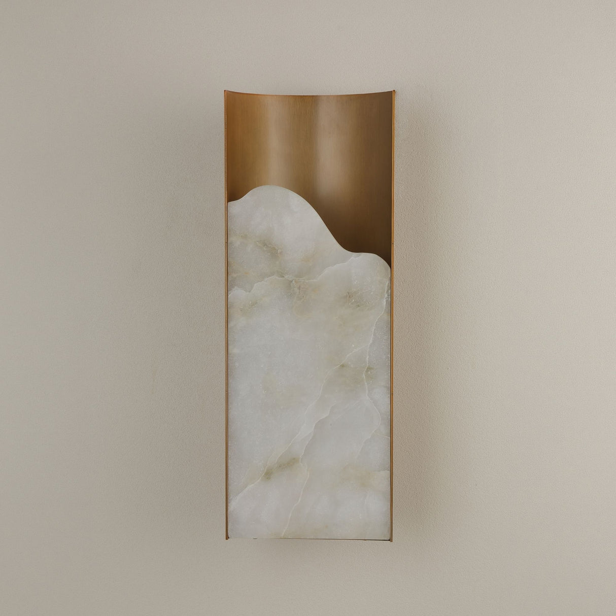 Caelith medium carved alabaster wall light by Niori with a tall Spanish alabaster slab set in a brushed brass frame on a neutral wall.