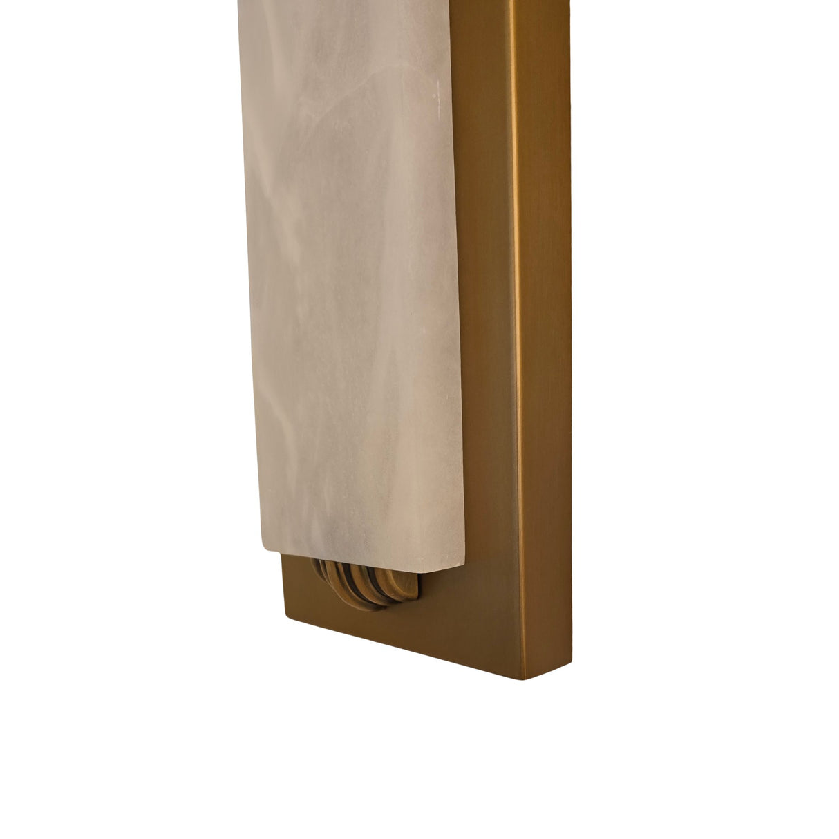 Close-up of the Niori Valora vertical alabaster wall light showing the brushed brass frame edge and brass cleat fixing securing the stone panel.