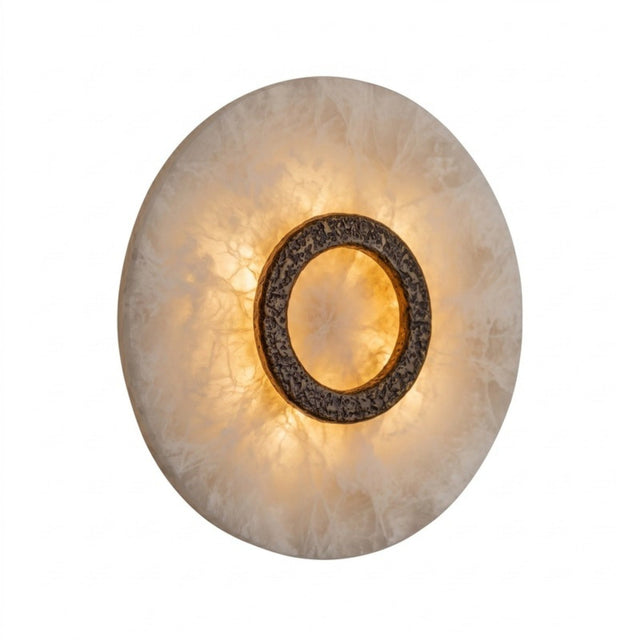 Ovaline round LED wall light with a domed alabaster disc and hammered brushed brass ring, glowing warmly against a plain white background.