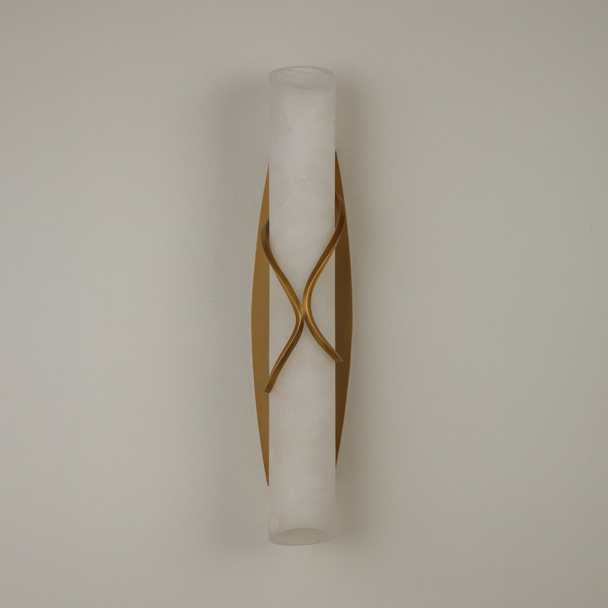 Valora LED Alabaster Wall Light with brushed brass crossover bands wrapping a cylindrical alabaster column, mounted on a plain light background.