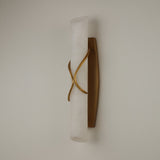 Valora LED Alabaster Wall Light in Brushed Brass, a vertical cylindrical alabaster column wrapped by curved brass bands, shown on a plain light background.