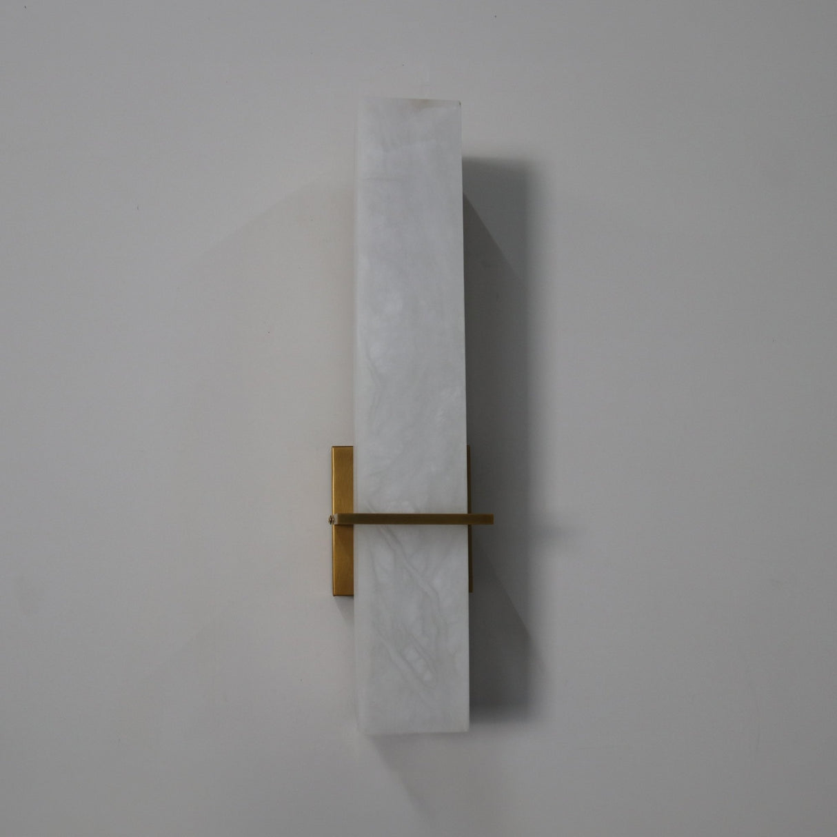 Aurevon LED Alabaster Vertical Panel Wall Light in Brushed Brass, elongated stone panel with horizontal brass arm and backplate, on a plain white background.