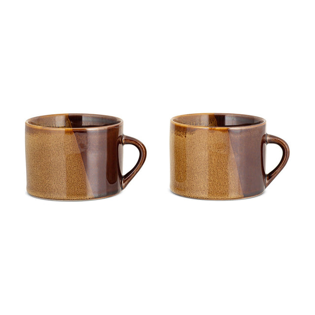 Naav Small Mug set of two in mustard, ceramic with a reactive two-tone glaze shading into brown, each with a looped handle, shown on a plain white background.