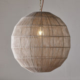 Nilaveli Woven Jute Sphere Pendant Light in natural jute, spherical globe shade with visible ribbed frame lines, hung on a chain with a single exposed bulb, shown against a plain grey wall.