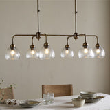 Kakira Ribbed Glass 6 Light Chandelier - Clear & Antique Brass in a dining room