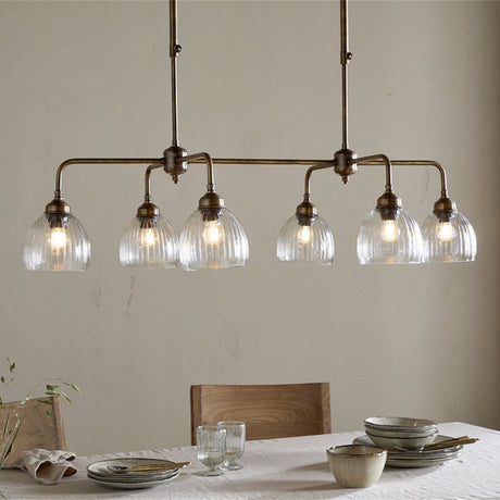 Kakira Ribbed Glass 6 Light Chandelier - Clear & Antique Brass in a dining room