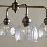 Kakira Ribbed Glass 6 Light Chandelier - Clear & Antique Brass in a dining room, view 2