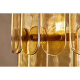 Close-up of the Itan Tiered Recycled Glass Pendant Light, showing amber glass paddles pinned to brass rings with warm light glowing between the overlapping tiers.