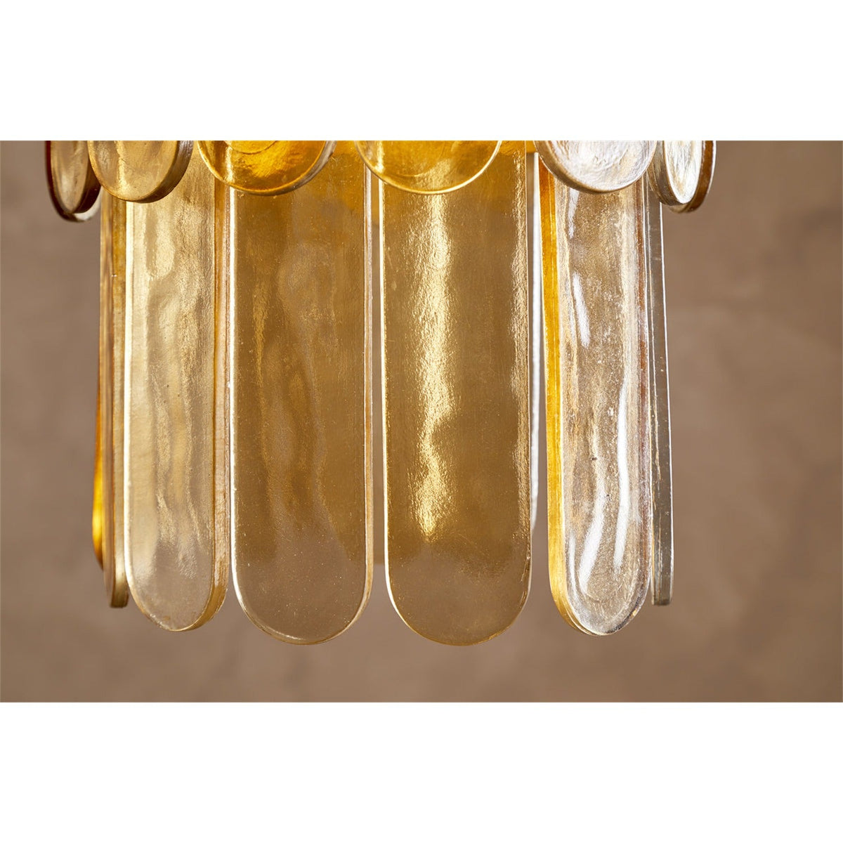 Close-up of the Itan Tiered Recycled Glass Pendant Light in amber, showing overlapping rounded glass paddles in a tiered arrangement against a neutral background.