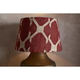 Haadu Large Jute Kilim Lampshade in rust and natural, a drum-shaped shade with a woven geometric pattern, shown fitted on a hammered brass lamp base.