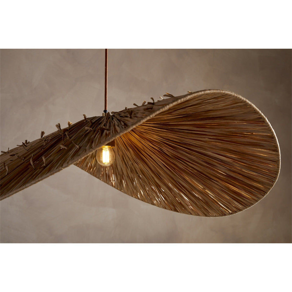 Essubi Raffia Organic Weave Pendant Light with a folded leaf-shaped shade, radiating strands, visible outer knots, and an exposed E27 bulb, shown against a neutral background.