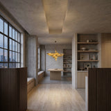 A modern, minimalist dining room with wood floors, a central table, built-in window seating, open shelves, and a Stratiform 20 Light Metal Chain Veil Chandelier in gold as an elegant sculptural fixture hanging from a recessed ceiling.
