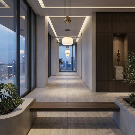 Niori Yoyo G9 Glass Pendant Light in gold with opal glass shade and spherical counterweight, hung in a modern hallway with city views at dusk.