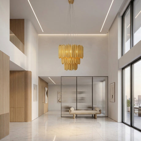 A modern, spacious lobby with high ceilings, large windows showing a cityscape, marble floors, wood accents, minimalist art, a beige bench, and a glass-walled office features the Aurelio 42 Light Brass Chandelier - Gold as its sculptural centerpiece.