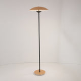 Niori Ginger LED floor lamp with a wood-veneer disc shade on a slim matt black steel stem and circular wood-veneer base, shown on a plain background.