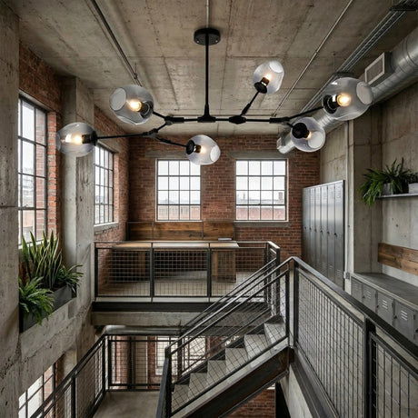 Niori Tree 6 Light Suspension in black with branching arms and glass globe shades, hanging in an industrial stairwell with exposed brick and concrete.