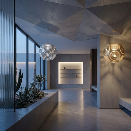 Niori Space 1 Light Perforated Sphere Pendant in gold lit in a modern concrete hallway with geometric ceiling, succulent planter and inset shelving.