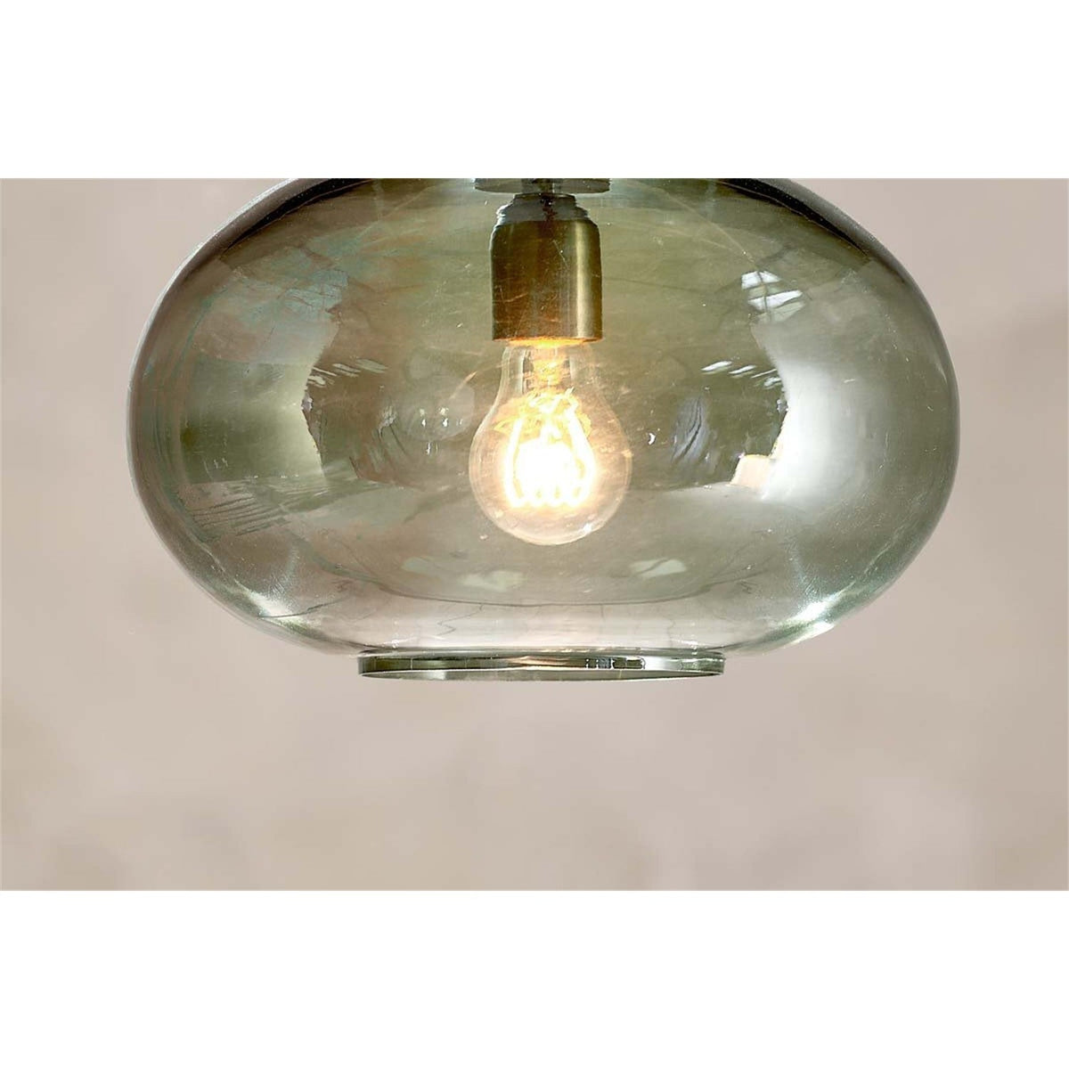 Otoro small round pendant light in smoky green recycled glass, flattened sphere shape with brass collar and visible bulb, set against a plain neutral background.