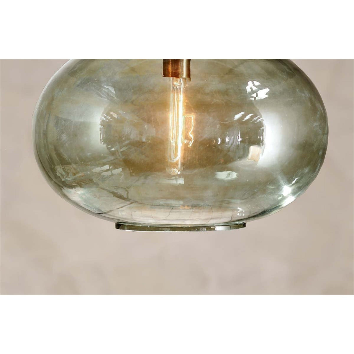 Close-up of the Otoro Large Round Recycled Glass Pendant Light in green, showing the smoky-tinted flattened sphere shade, brass collar fitting, and visible bulb against a plain light background.