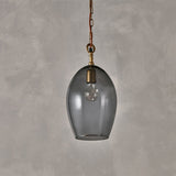 Otoro Small Oval Recycled Glass Pendant Light in smoke, an egg-shaped glass shade with brass collar and chain on rust fabric flex, shown against a plain grey background.